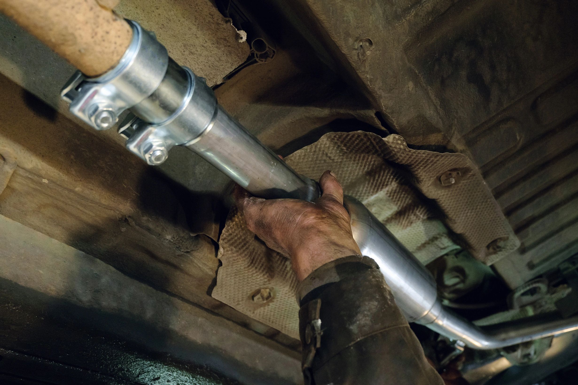 Mechanic installing an exhaust pipe