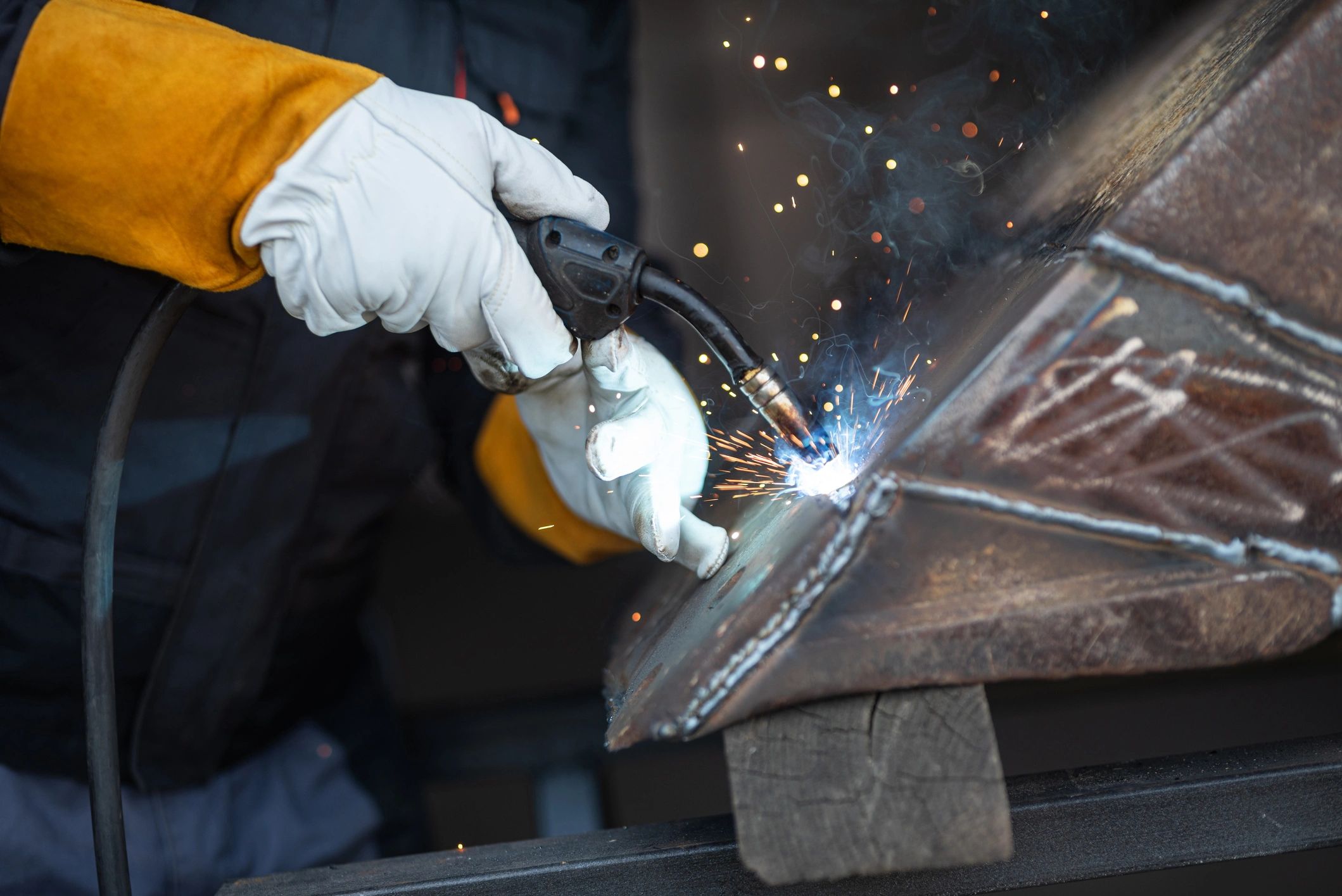 Welder joining metal parts in a workshop