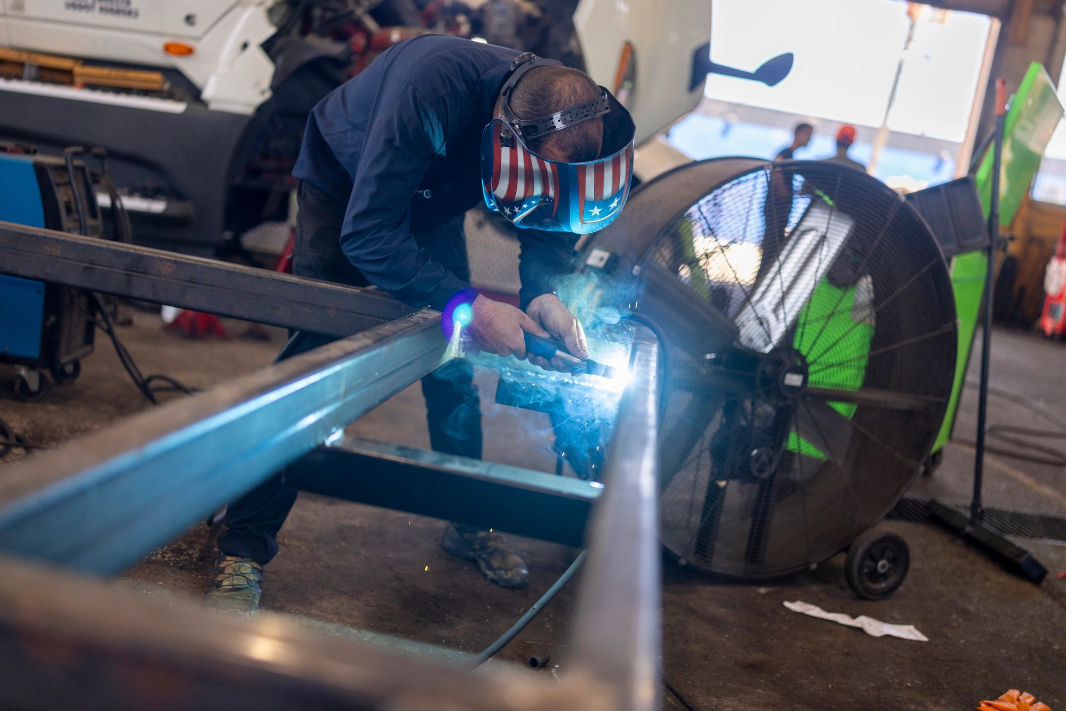 Mechanic welding metal frame with sparks